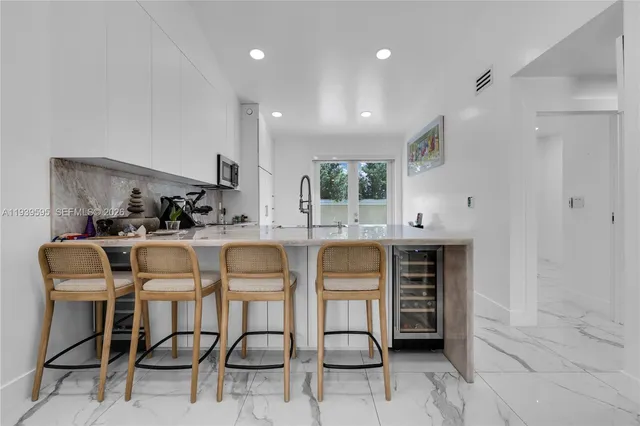 a kitchen with stainless steel appliances kitchen island granite countertop a table and chairs in it