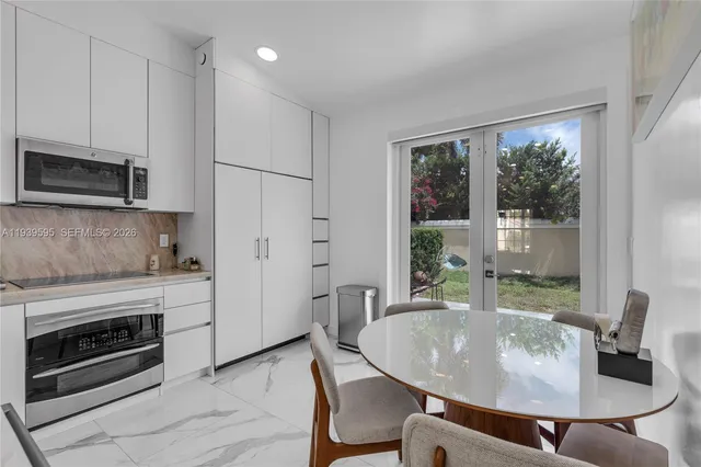 a dining table chair next to a window with kitchen view