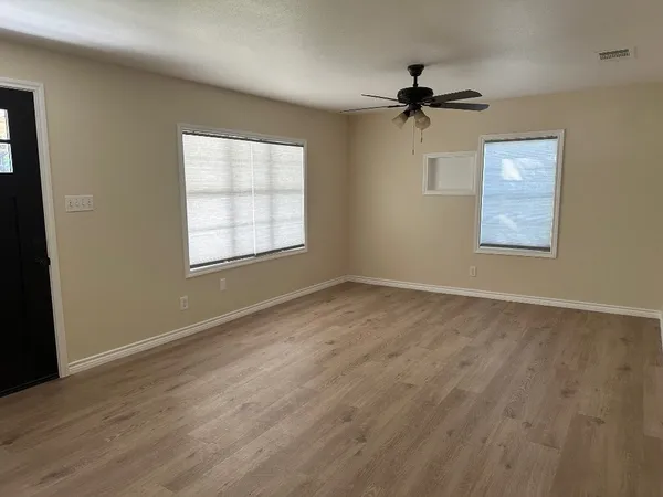 wooden floor in an empty room with a window