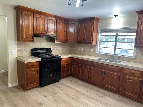 a kitchen with stainless steel appliances granite countertop wooden cabinets and a stove top oven