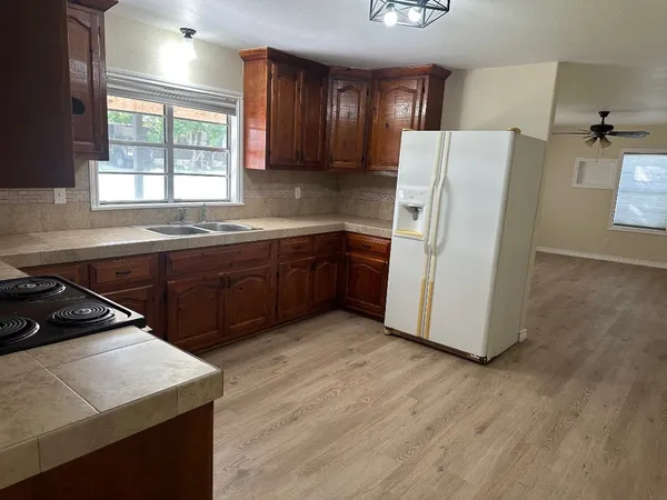 a kitchen with wooden cabinets a sink a stove a refrigerator and island