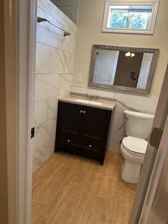 a bathroom with a toilet a sink and mirror