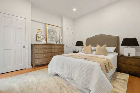 a spacious bedroom with a bed and painting on the wall