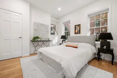 a bedroom with a bed and wooden floor