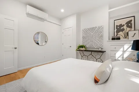 a bedroom with a large bed and a chandelier