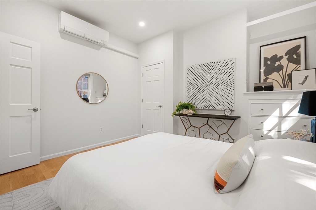 18 Melrose Street, Unit 1 Boston, MA 02116 - Photo 16 of 24 a bedroom with a large bed and a chandelier