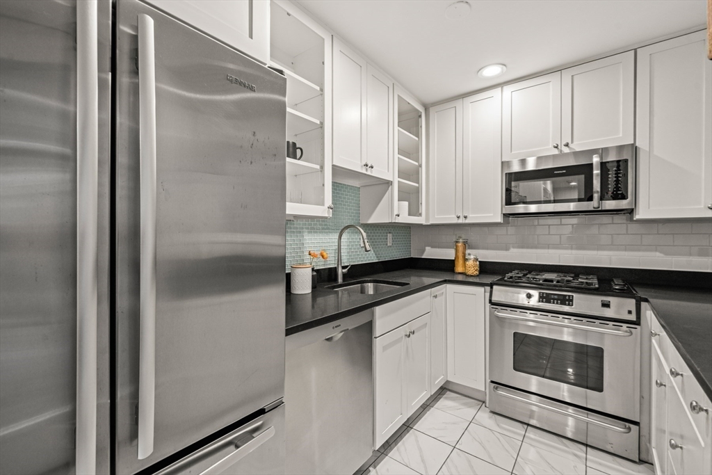 18 Melrose Street, Unit 1 Boston, MA 02116 - Photo 8 of 24 a kitchen with stainless steel appliances granite countertop a stove a refrigerator and a microwave