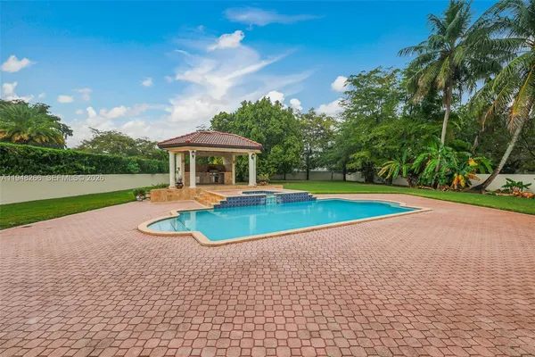 a view of a house with pool and chairs
