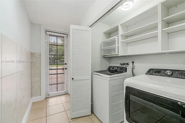 an empty room with windows and chandelier fan