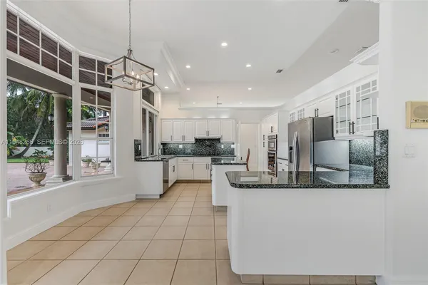 a kitchen with stainless steel appliances granite countertop a refrigerator and a sink