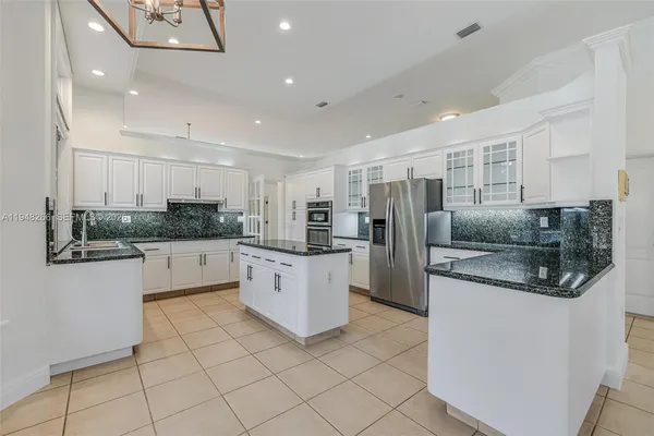 a kitchen with stainless steel appliances kitchen island granite countertop a stove and cabinets
