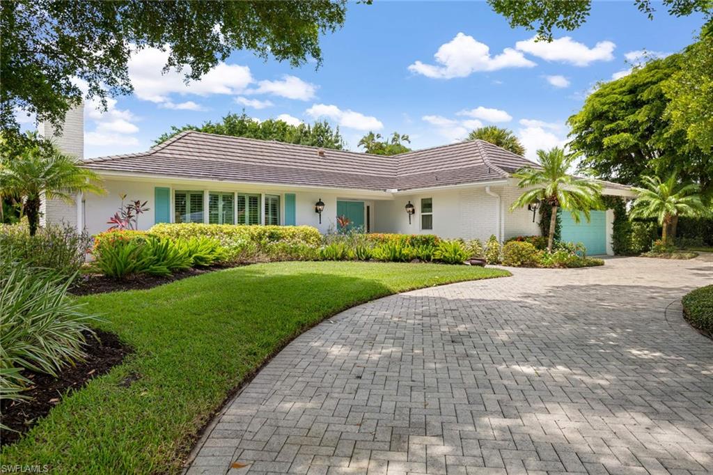 2989 Regatta Road Naples, FL 34103 - Photo 1 of 20 a front view of a house with a garden