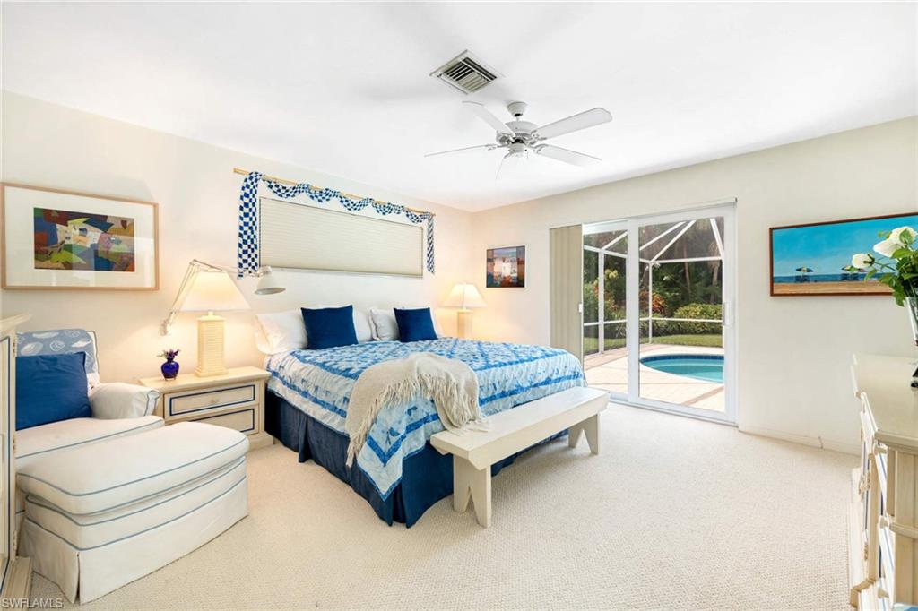2989 Regatta Road Naples, FL 34103 - Photo 14 of 20 a bedroom with a large bed and a chandelier