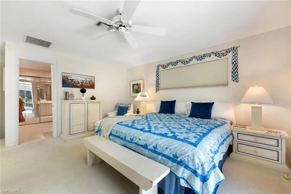 2989 Regatta Road Naples, FL 34103 - Photo 16 of 20 a bedroom with a bed and a chandelier