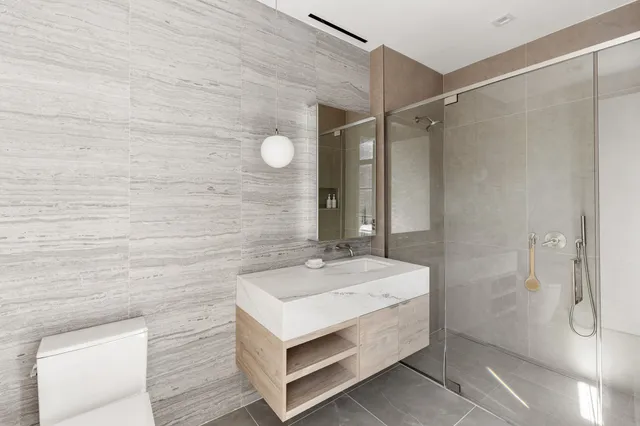 a bathroom with a sink a toilet and shower