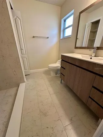 a bathroom with a sink a toilet a mirror and shower