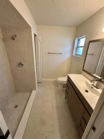 a bathroom with a tub shower vanity and a sink