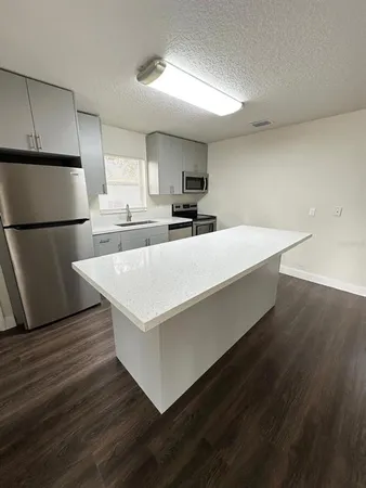 a large white kitchen with wooden floor
