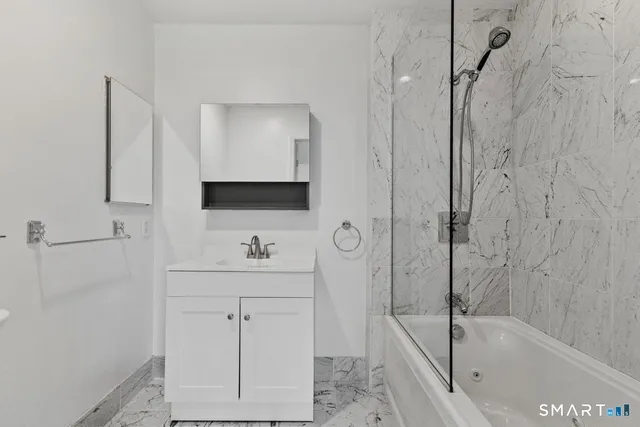 a bathroom with a bathtub a sink a vanity and a shower