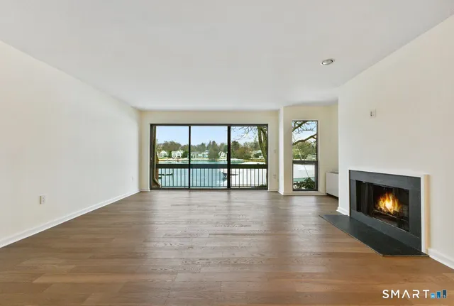 a view of an empty room with a fireplace and a window