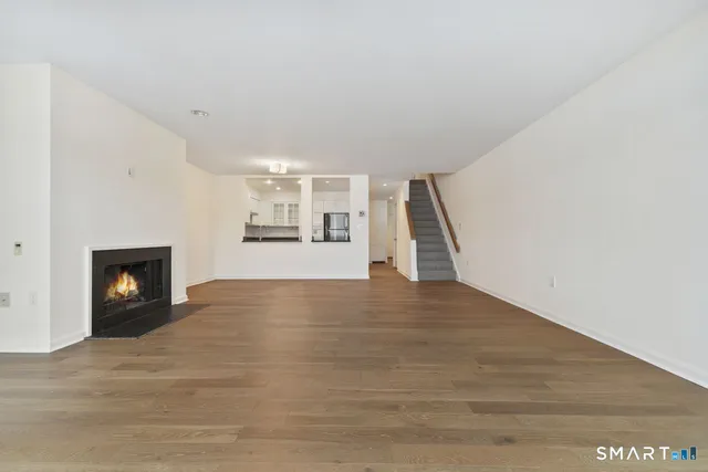 a view of empty room with wooden floor and fireplace