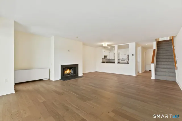 a view of a livingroom with wooden floor and a fireplace