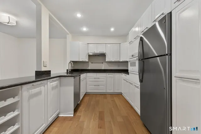 a kitchen with white cabinets and stainless steel appliances