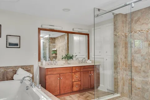 a bathroom with a double vanity sink mirror and shower