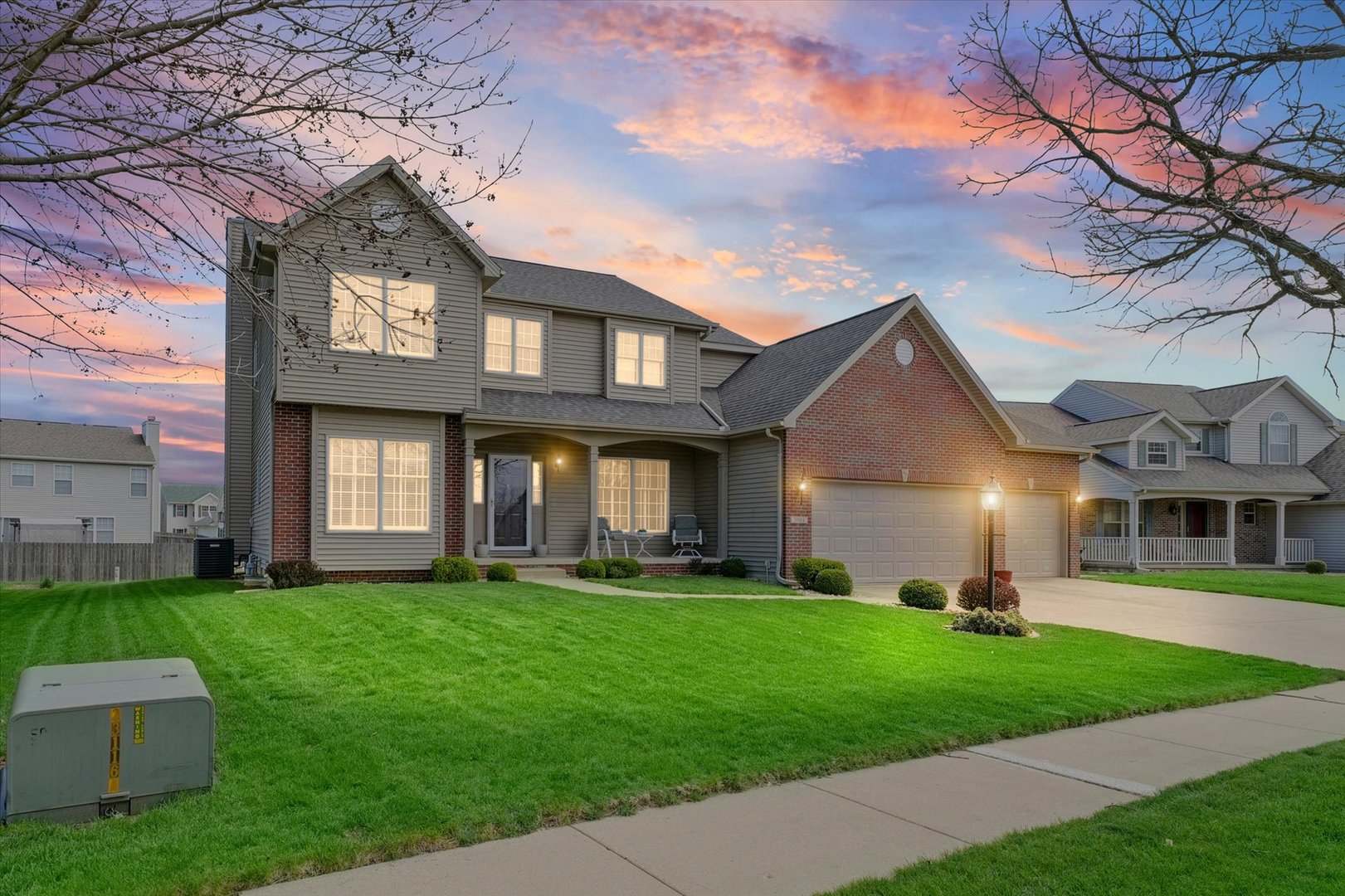 a front view of a house with a yard and trees