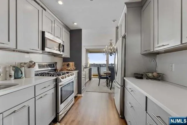 a kitchen with stainless steel appliances granite countertop a stove a sink and a refrigerator