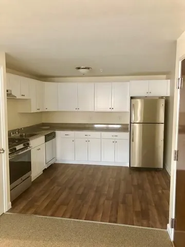 a kitchen with wooden floors and stainless steel appliances