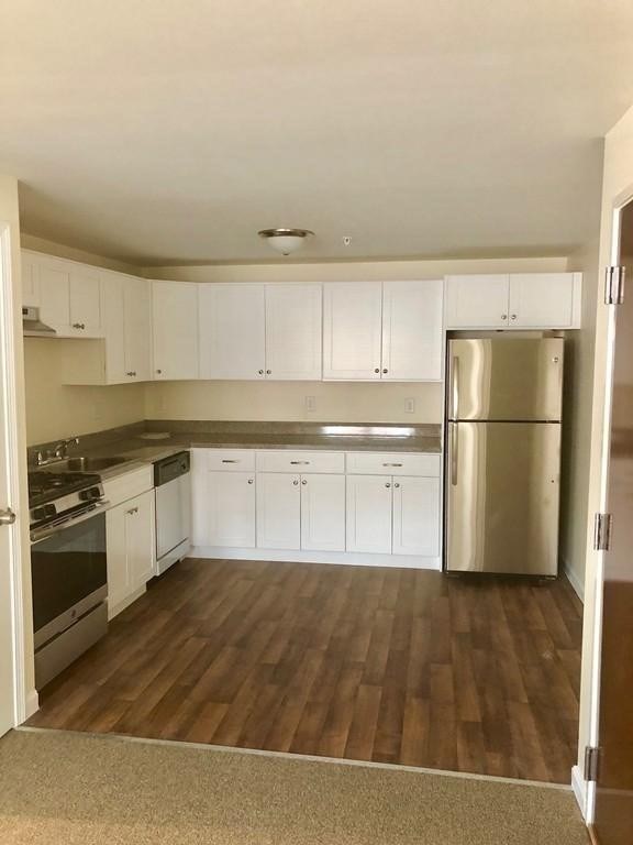 a kitchen with wooden floors and stainless steel appliances