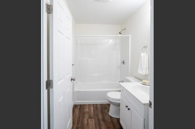 361 Hildreth Street, Unit 24 Lowell, MA 01850 - Photo 6 of 9 a bathroom with a granite countertop toilet a sink and a bathtub