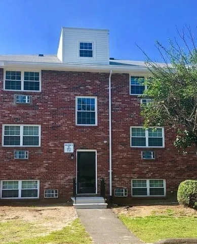 a brick house with a large window and a yard