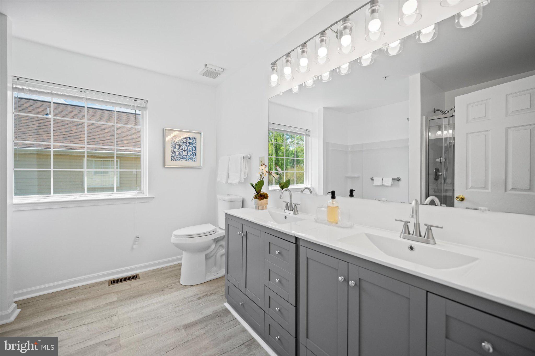 12908 Windbrook Drive Clinton, MD 20735 - Photo 18 of 67 a spacious bathroom with a double vanity sink a toilet and a mirror