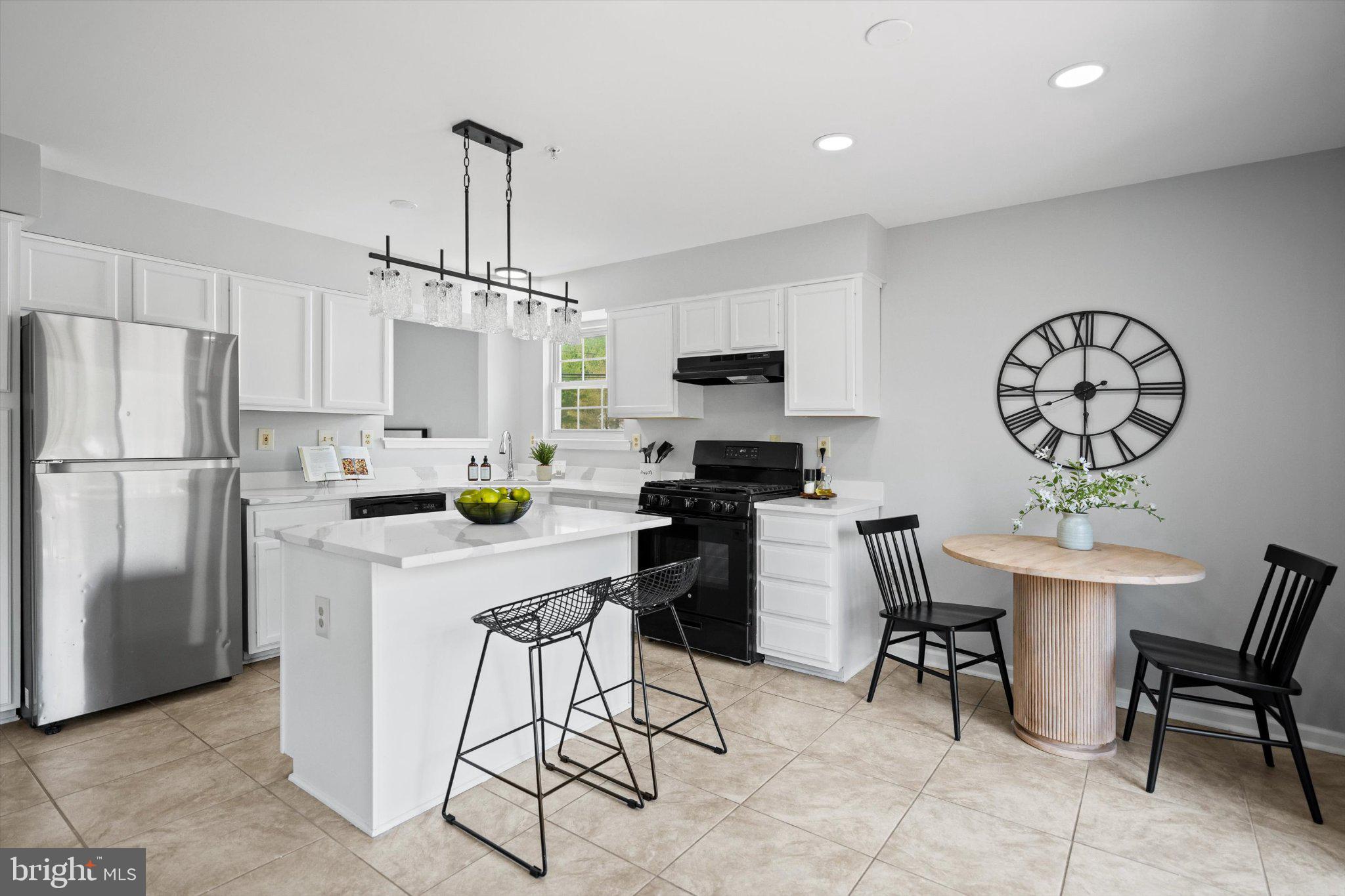 12908 Windbrook Drive Clinton, MD 20735 - Photo 21 of 67 a kitchen with stainless steel appliances a dining table chairs a refrigerator a stove a microwave and dining table