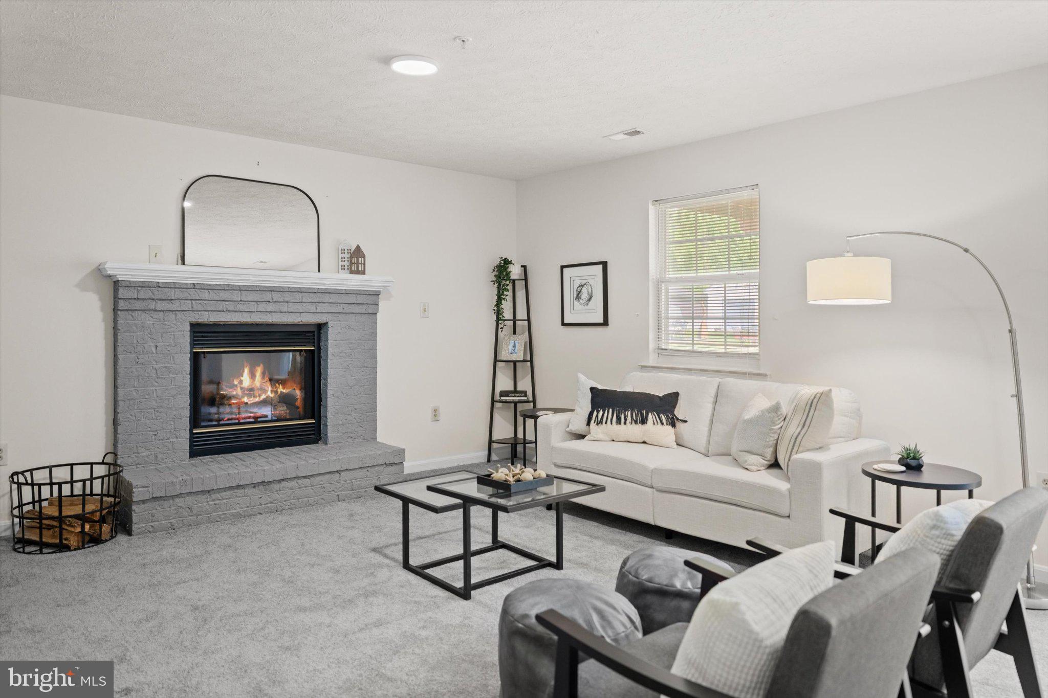 12908 Windbrook Drive Clinton, MD 20735 - Photo 25 of 67 a living room with furniture a fireplace and a window