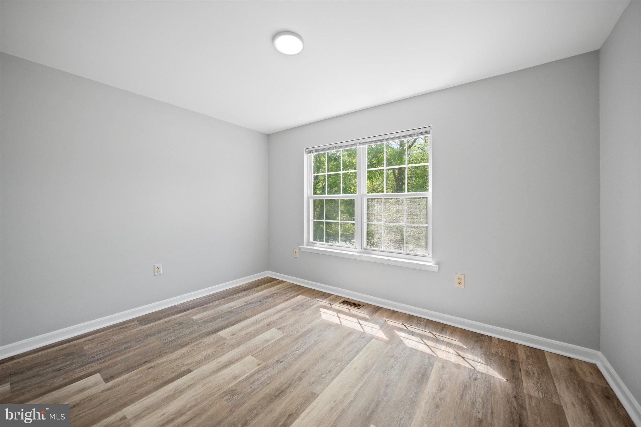 12908 Windbrook Drive Clinton, MD 20735 - Photo 28 of 67 an empty room with wooden floor and windows