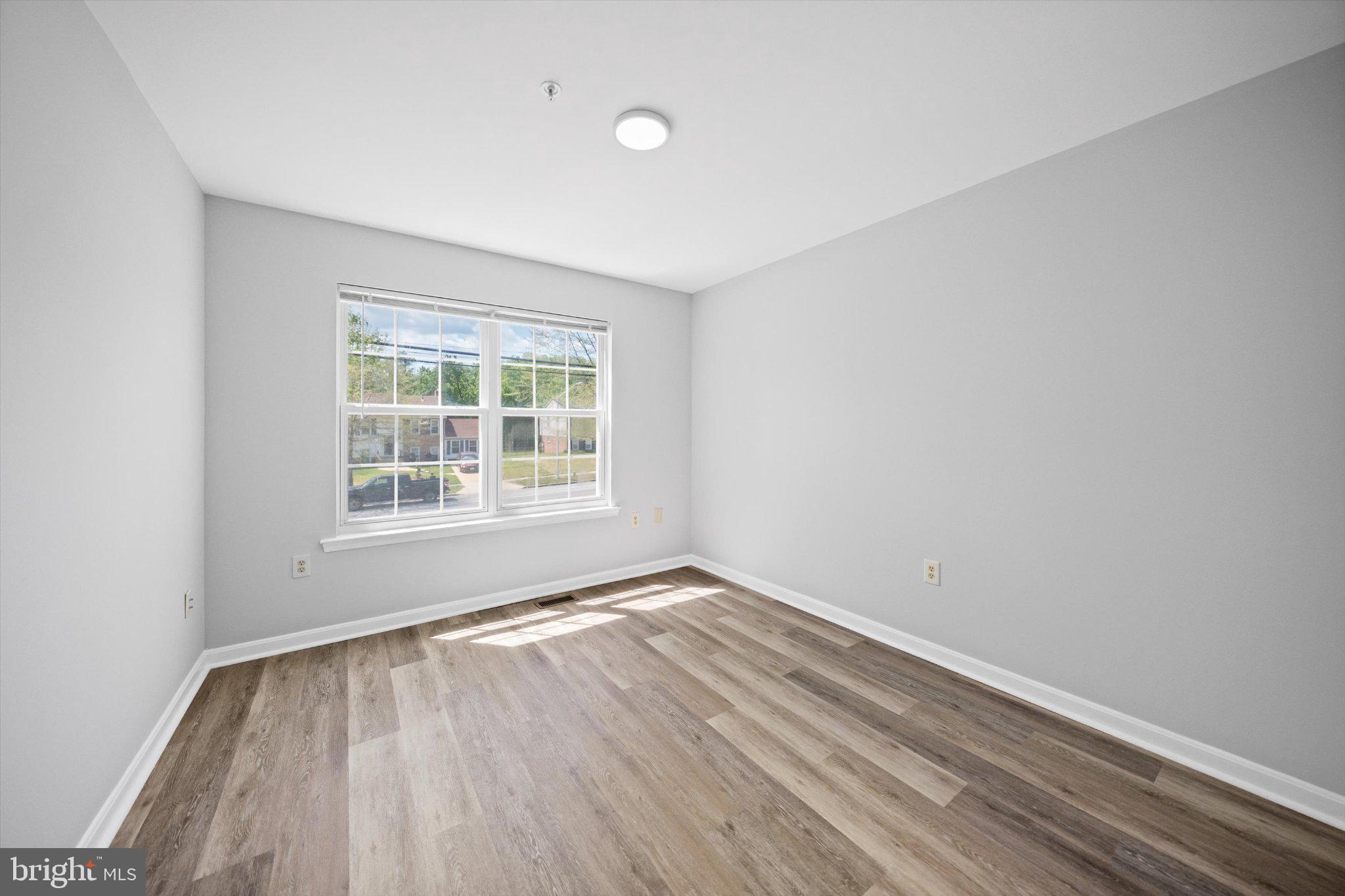 12908 Windbrook Drive Clinton, MD 20735 - Photo 30 of 67 an empty room with wooden floor and windows