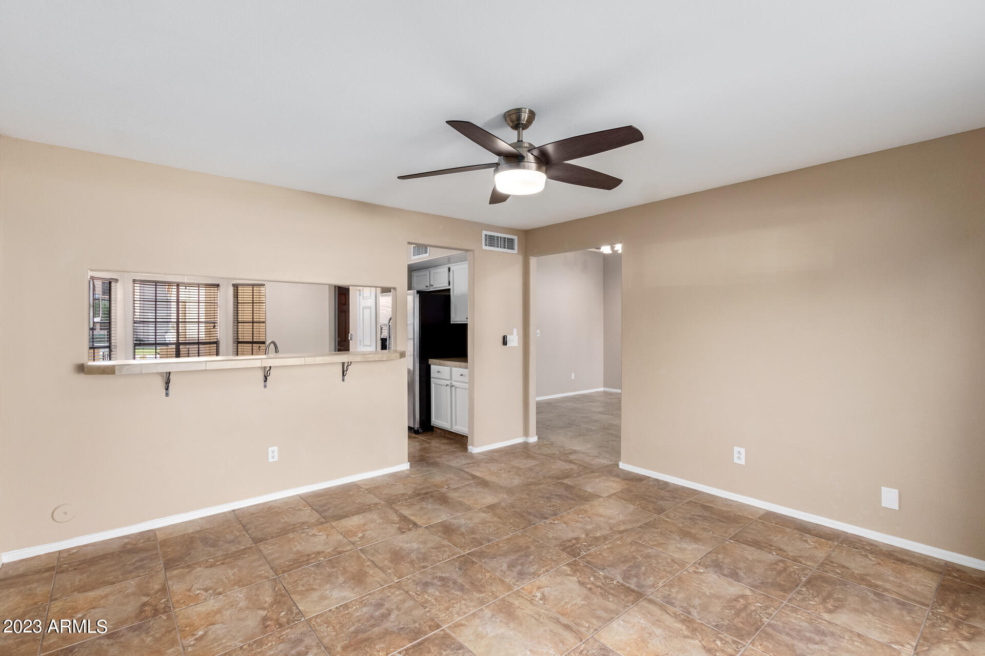 4266 East Agave Road Phoenix, AZ 85044 - Photo 9 of 54 a view of a big room with wooden floor and a ceiling fan