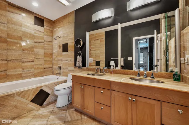 a bathroom with a granite countertop toilet sink and mirror