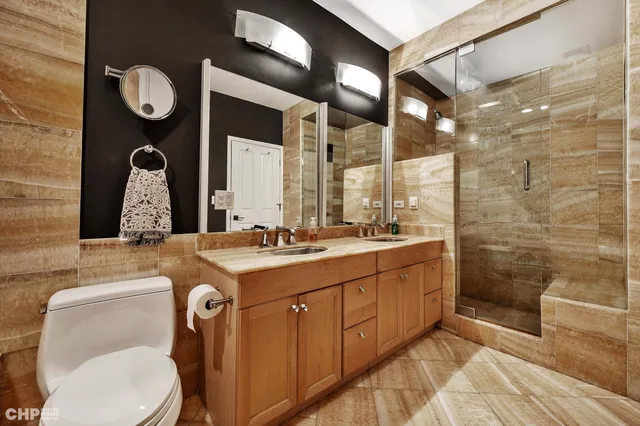 a bathroom with a granite countertop sink mirror vanity and toilet