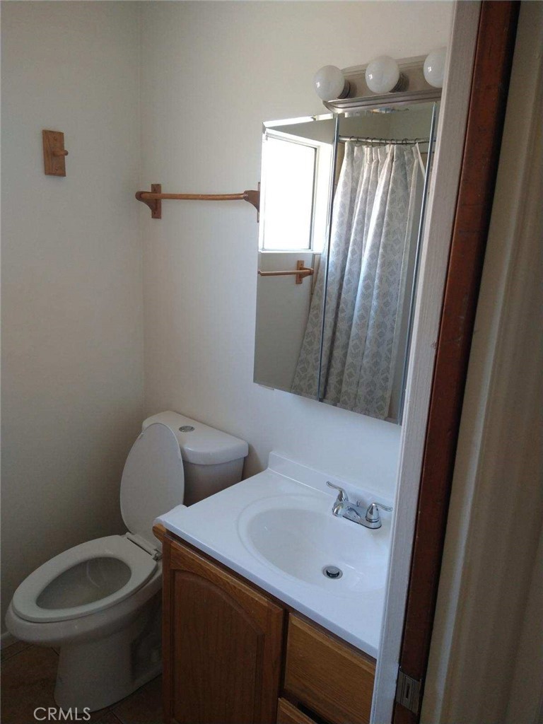 21988 Mojave River Road Cedarpines Park, CA 92322 - Photo 3 of 10 a bathroom with a toilet sink and mirror