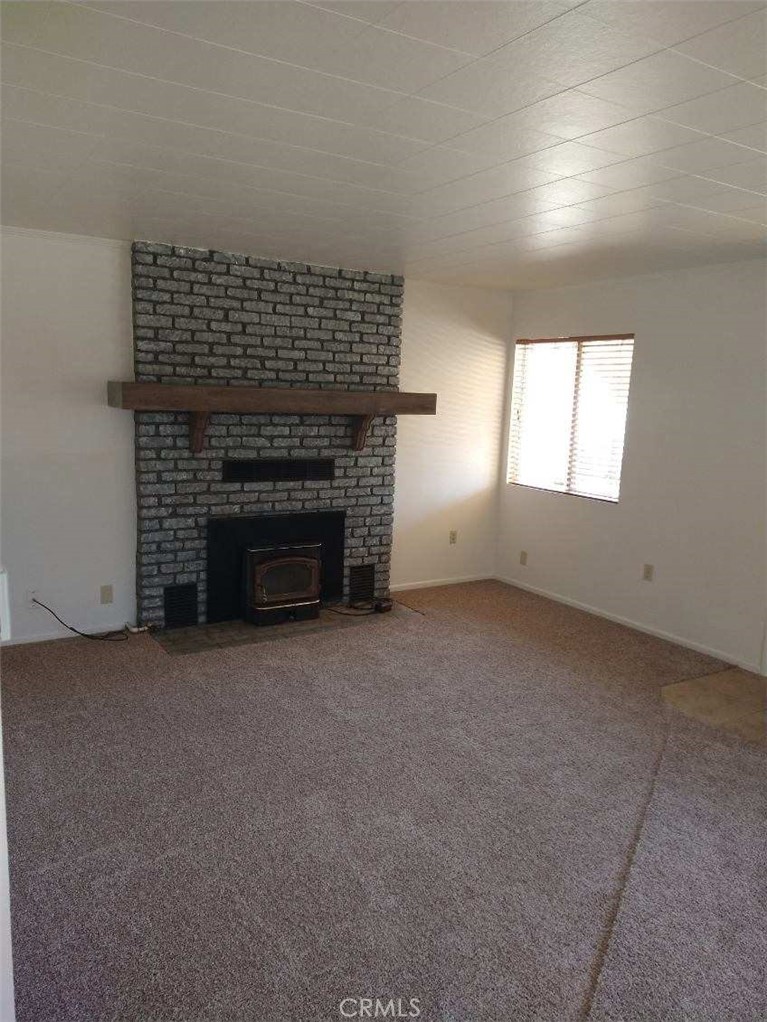 21988 Mojave River Road Cedarpines Park, CA 92322 - Photo 9 of 10 an empty room with a fireplace
