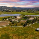an aerial view of residential houses with outdoor space and ocean view