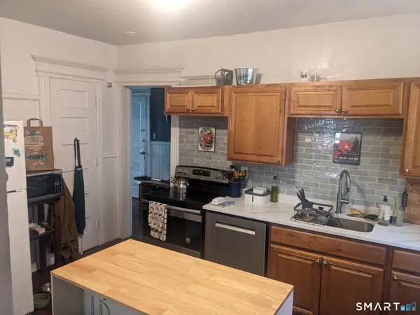 a kitchen with stainless steel appliances a sink stove and refrigerator