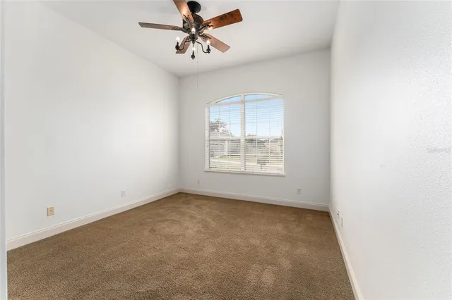 an empty room with fan and entryway