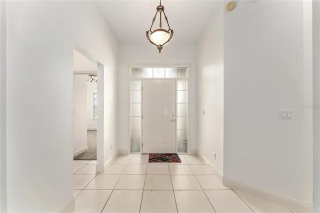 a view of an empty room with wooden floor and windows