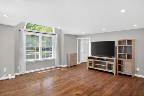 a view of room with wooden floor and windows