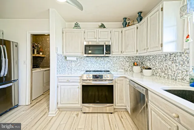 a kitchen with stainless steel appliances granite countertop a stove refrigerator and microwave